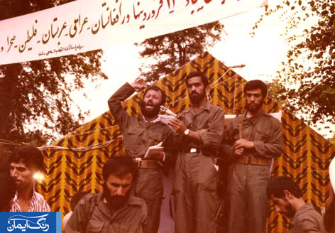 شهید کریمی در حال سخنرانی - شخصی که در سمت راست شهید ایستاده و میکروفون را نگه داشته، سردار نقدی فرمانده فعلی نیروی مقاومت بسیج کشور است.